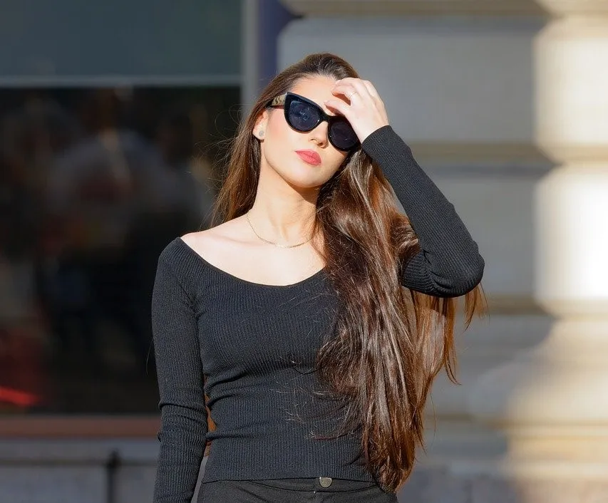 Frau mit langen braunen Haaren und Sonnenbrille