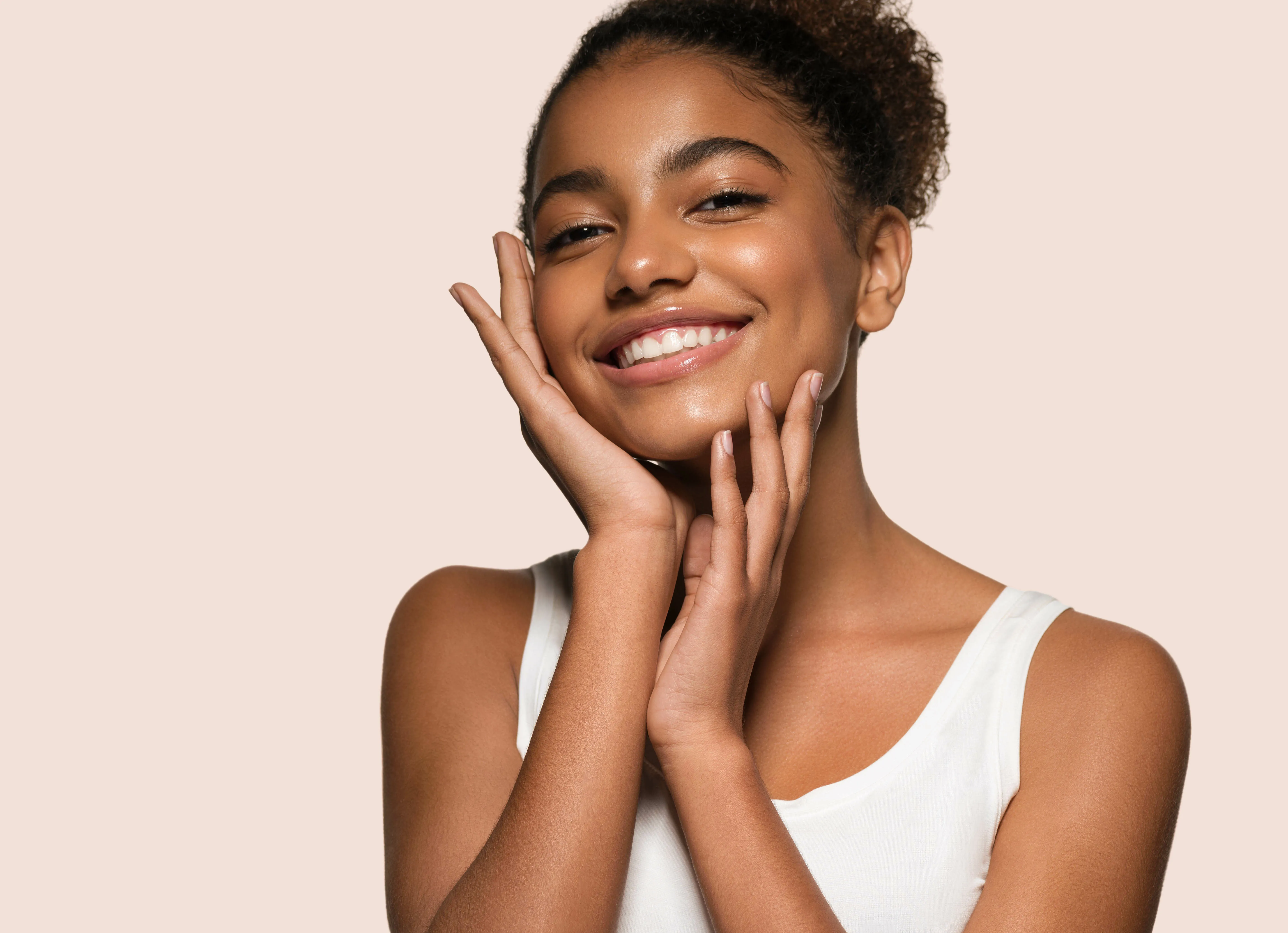 Frau mit makelloser Haut hält ihr Gesicht