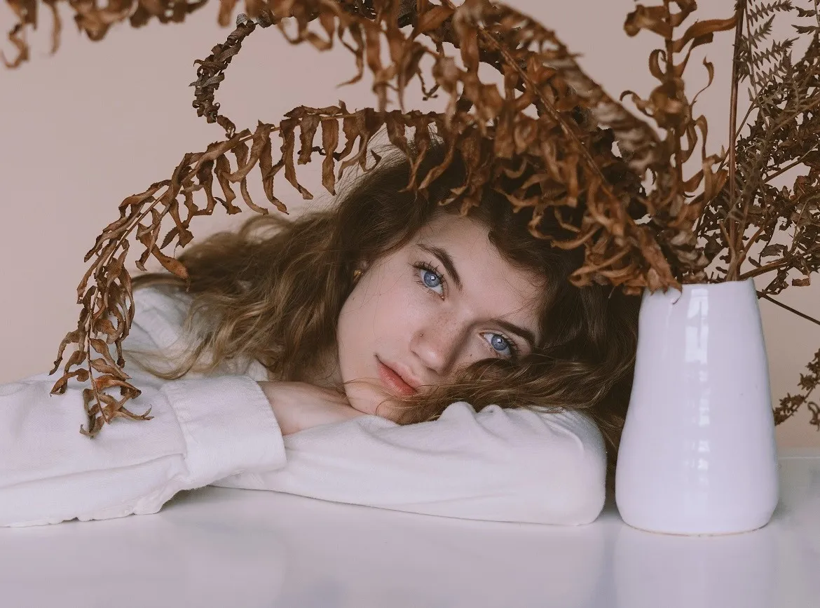 Brünette Frau neben Blumenstock