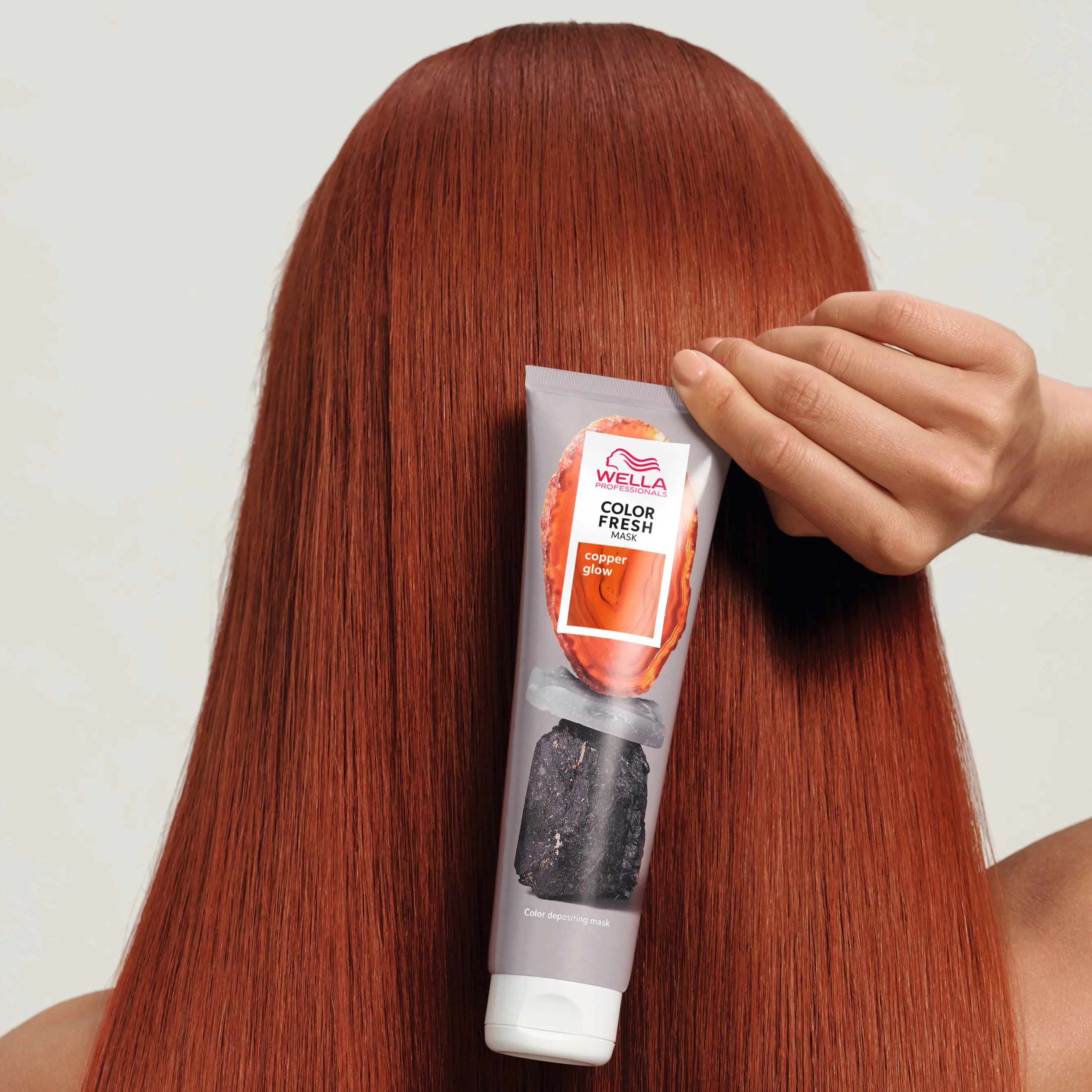 Frau mit Kupfer farbenen Haaren hält Wella Color Fresh Mask Kupfer an ihr Haar
